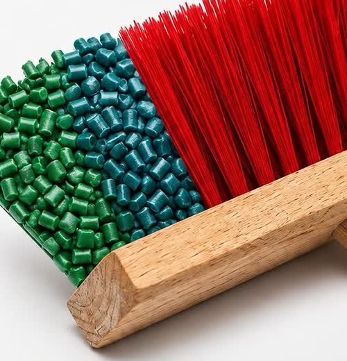 Grânulos de plástico reciclado verde e azul se transformando em cerda vermelha de monofilamento.